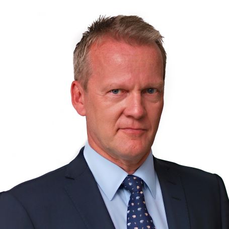 Professor Pasi Sahlberg head shot of man with short grey hair wearing a navy suit white light blue business shirt and dark blue spotted tie.