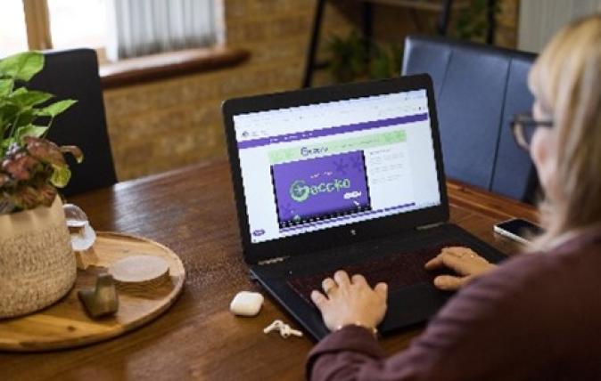 Woman at home sitting at a dining table on her laptop